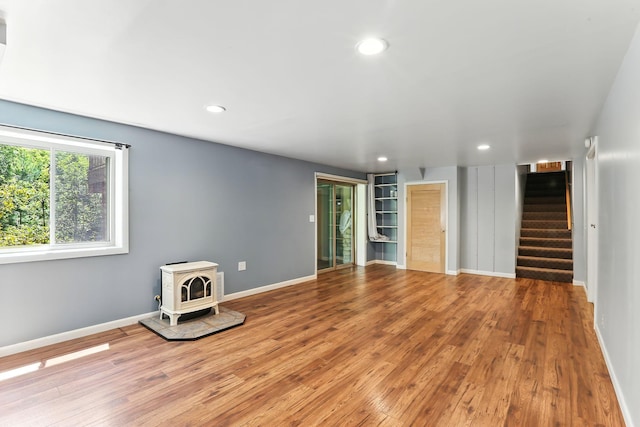 5820 139th St W, Apple Valley, MN 55124 - spare room featuring wood finished floors, stairs, a wood stove, and recessed lighting