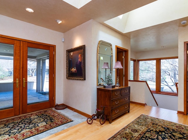 9002 Riley Lake Rd, Eden Prairie, MN 55347 - entryway featuring a skylight, healthy amount of natural light, light wood-style flooring, and baseboards