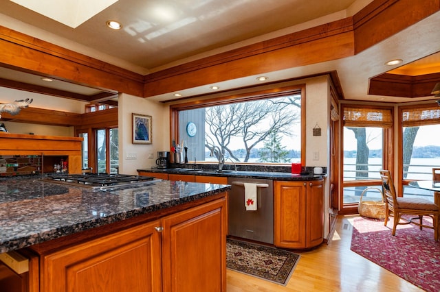 9002 Riley Lake Rd, Eden Prairie, MN 55347 - kitchen with stainless steel appliances, light wood finished floors, recessed lighting, brown cabinetry, and a skylight