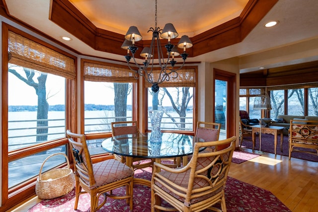 9002 Riley Lake Rd, Eden Prairie, MN 55347 - dining area featuring a chandelier, a water view, wood finished floors, a tray ceiling, and recessed lighting