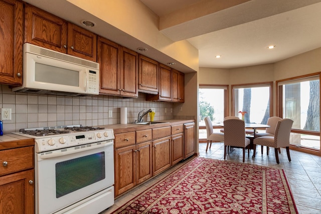 9002 Riley Lake Rd, Eden Prairie, MN 55347 - kitchen with white appliances, a sink, decorative backsplash, brown cabinetry, and recessed lighting