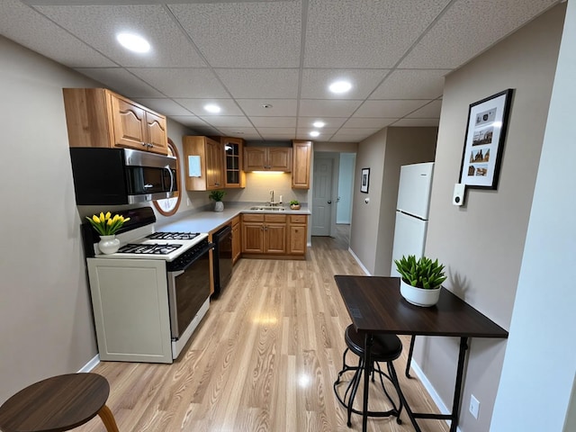 125 1st St, Dresser, WI 54009 - kitchen featuring white appliances, a sink, light wood-style flooring, light countertops, and recessed lighting