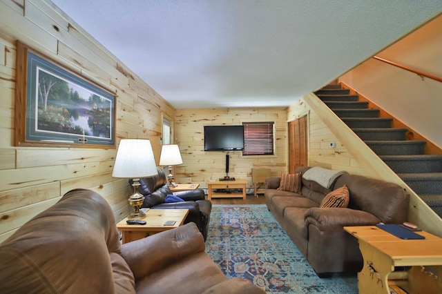 living room featuring wood walls and stairs
