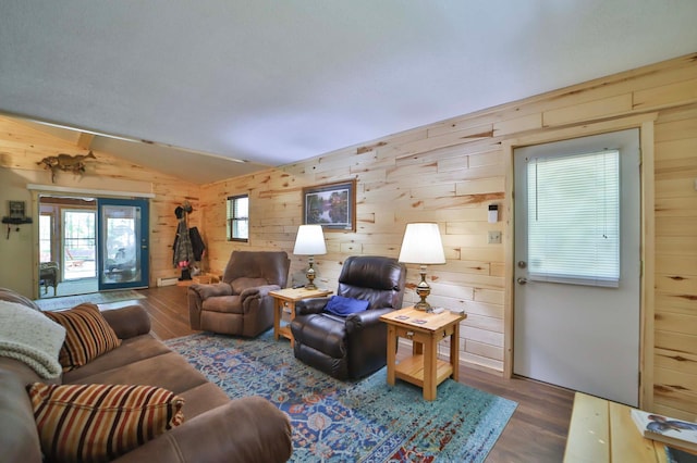 living area with wooden walls, wood finished floors, and vaulted ceiling
