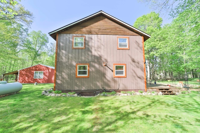 back of property featuring a wooden deck and a lawn