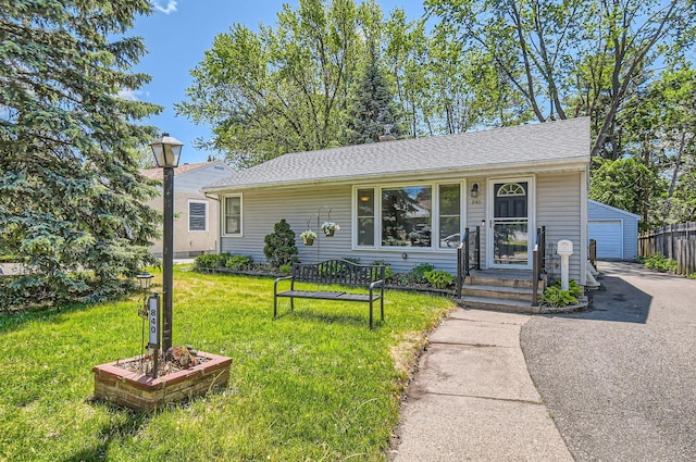 840 California Ave W, Saint Paul, MN 55117 - view of front of home with an outdoor structure, a front lawn, a detached garage, and a shingled roof