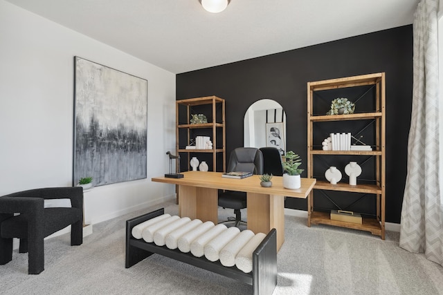 home office featuring baseboards, arched walkways, and carpet floors