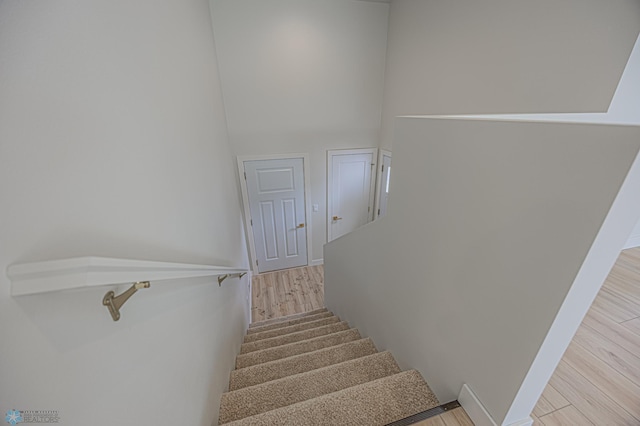 stairway with wood finished floors and baseboards