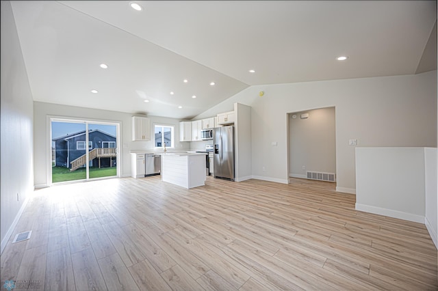 unfurnished living room featuring vaulted ceiling, light wood finished floors, baseboards, recessed lighting, and a sink