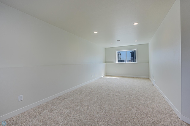 empty room featuring light carpet, recessed lighting, and baseboards