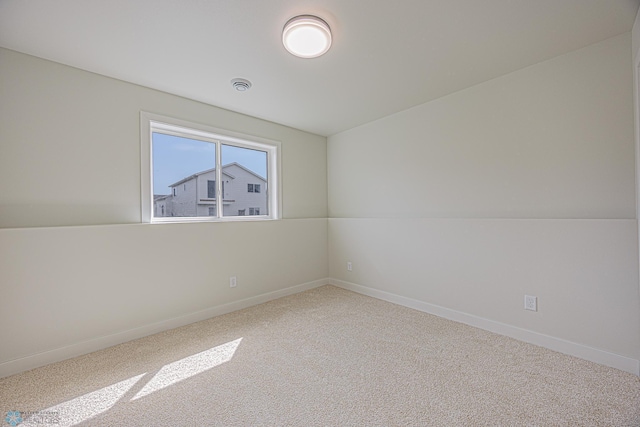 carpeted empty room featuring baseboards