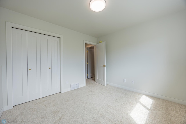 unfurnished bedroom with carpet floors, a closet, and baseboards
