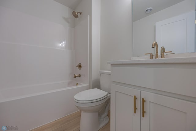 bathroom featuring toilet, wood finished floors, vanity, and shower / bath combination