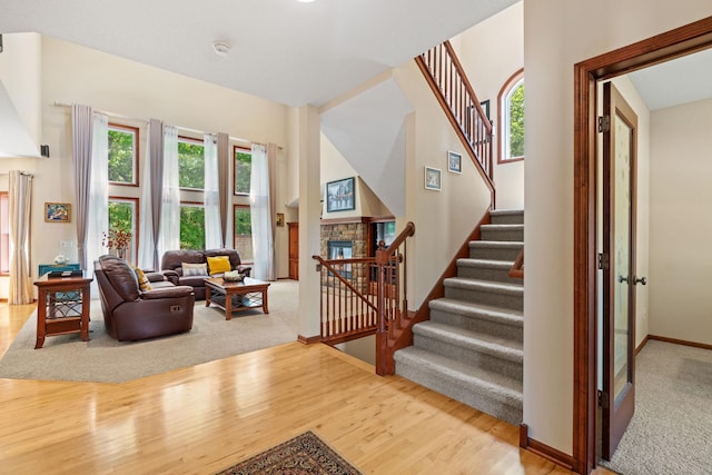 12800 Garrett Ct, Apple Valley, MN 55124 - stairs with wood finished floors, a fireplace, baseboards, carpet flooring, and a towering ceiling