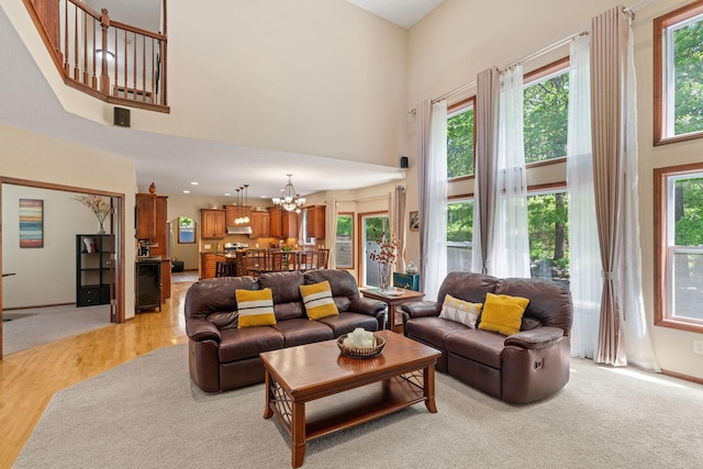 12800 Garrett Ct, Apple Valley, MN 55124 - living area featuring a towering ceiling, a chandelier, and light wood finished floors