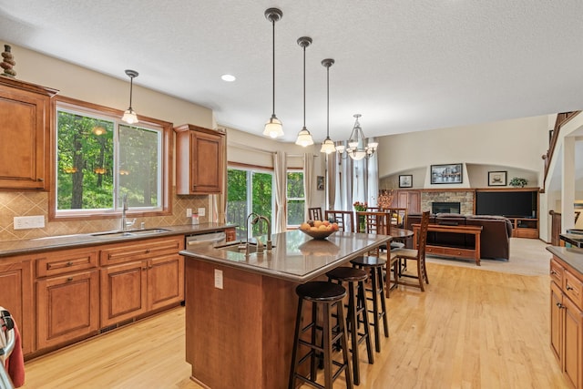 12800 Garrett Ct, Apple Valley, MN 55124 - kitchen with a sink, light wood-style floors, a breakfast bar area, brown cabinetry, and recessed lighting