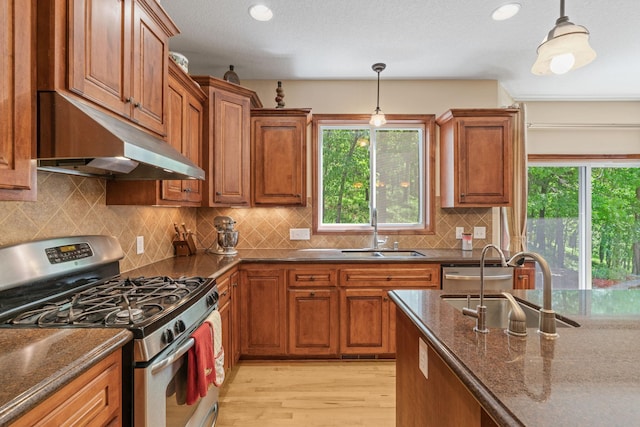 12800 Garrett Ct, Apple Valley, MN 55124 - kitchen with appliances with stainless steel finishes, under cabinet range hood, a sink, brown cabinets, and recessed lighting