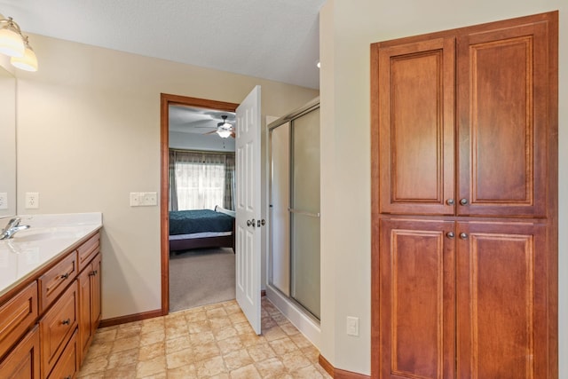 12800 Garrett Ct, Apple Valley, MN 55124 - bathroom featuring baseboards, vanity, a shower stall, and a ceiling fan