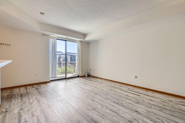 820 Emerald St Unit 402, Saint Paul, MN 55114 - spare room with a textured ceiling, light wood finished floors, and baseboards