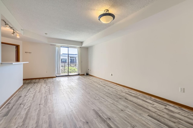 820 Emerald St Unit 402, Saint Paul, MN 55114 - unfurnished room featuring a textured ceiling, light wood-style floors, and baseboards
