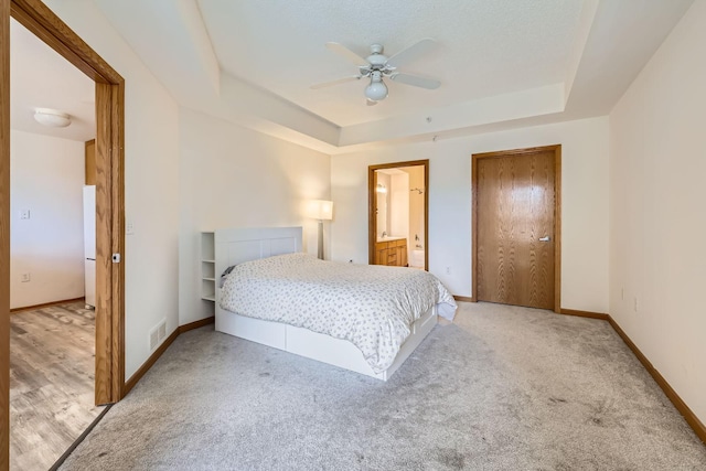 820 Emerald St Unit 402, Saint Paul, MN 55114 - bedroom featuring a tray ceiling, light colored carpet, baseboards, and ensuite bath