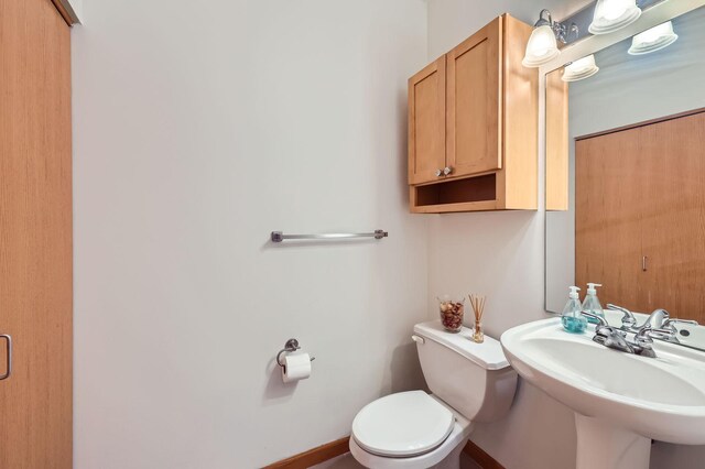 820 Emerald St Unit 402, Saint Paul, MN 55114 - half bathroom featuring a sink, toilet, and baseboards