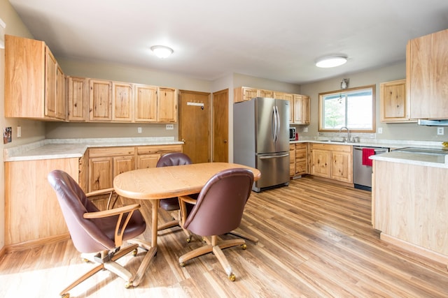 kitchen with light countertops, light wood-style floors, stainless steel appliances, and light brown cabinetry