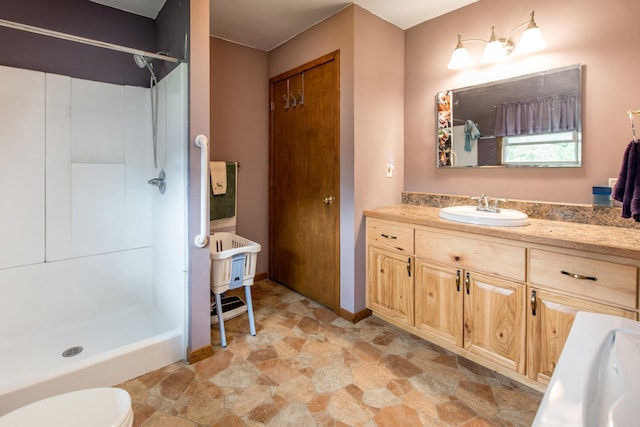 full bath with a shower stall, stone finish flooring, vanity, and toilet