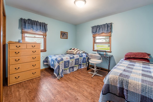 bedroom with baseboards and wood finished floors