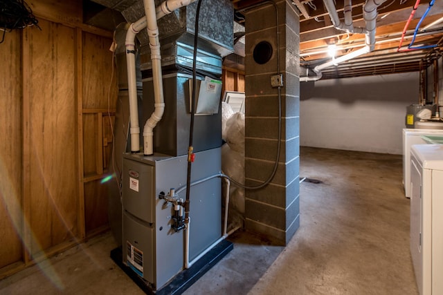 utility room featuring washer / clothes dryer, water heater, and heating unit