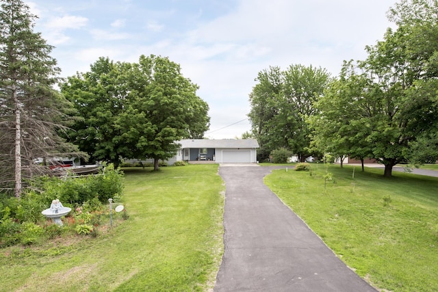 view of front of house featuring a garage, driveway, and a front yard