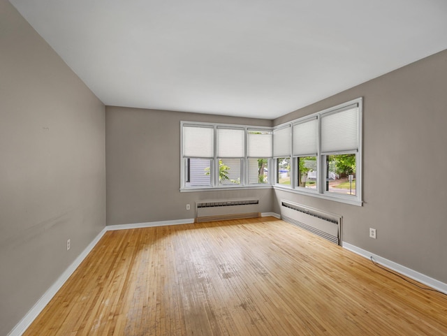 517 Olive St S, Waconia, MN 55387 - empty room featuring radiator heating unit and light wood-style flooring