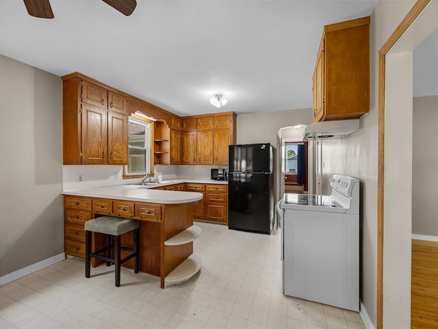 517 Olive St S, Waconia, MN 55387 - kitchen with freestanding refrigerator, range, a peninsula, brown cabinetry, and light countertops