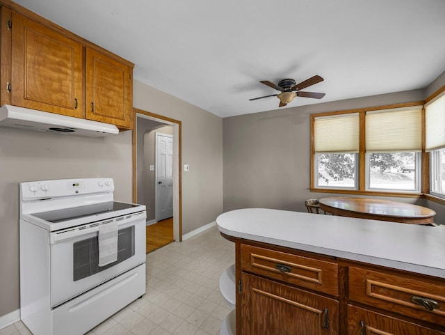 517 Olive St S, Waconia, MN 55387 - kitchen with white electric range, under cabinet range hood, light floors, a ceiling fan, and light countertops