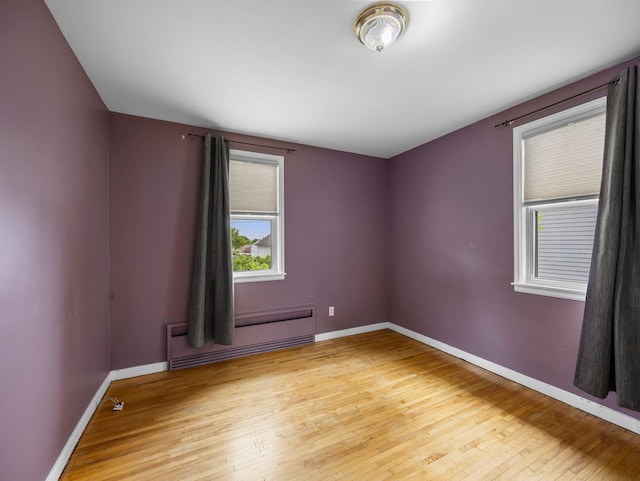 517 Olive St S, Waconia, MN 55387 - unfurnished room featuring a baseboard heating unit and light wood finished floors