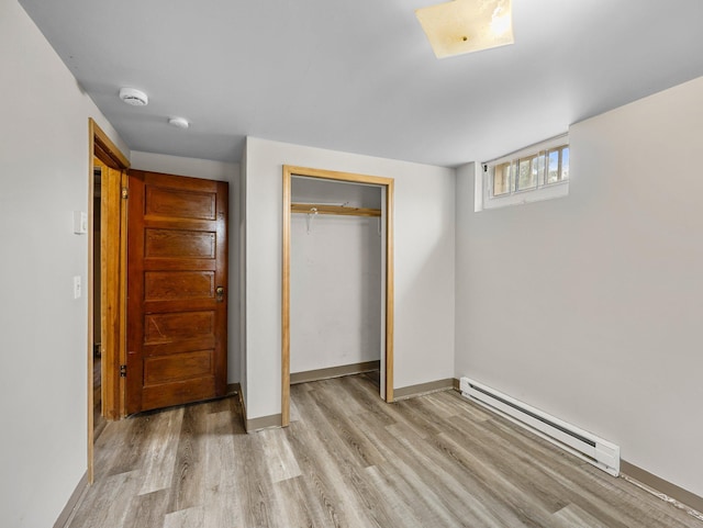 517 Olive St S, Waconia, MN 55387 - unfurnished bedroom with a baseboard heating unit, light wood finished floors, and a closet