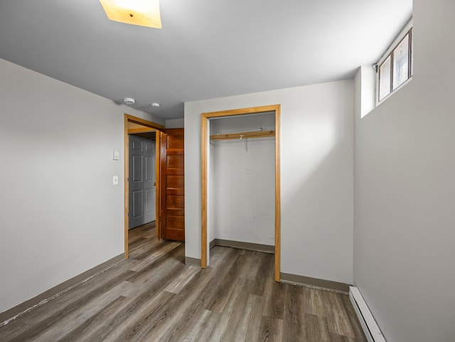 517 Olive St S, Waconia, MN 55387 - unfurnished bedroom with wood finished floors, a closet, a baseboard radiator, and baseboard heating