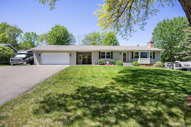 ranch-style home featuring a garage, driveway, a chimney, and a front lawn
