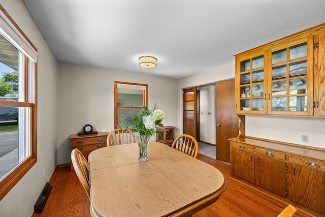dining area featuring dark wood-style flooring and healthy amount of natural light