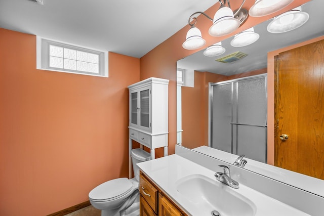bathroom featuring a stall shower, toilet, vanity, and baseboards
