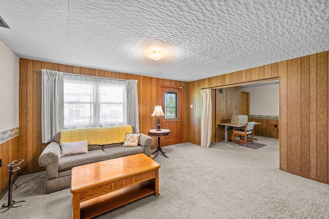 carpeted living room featuring wooden walls