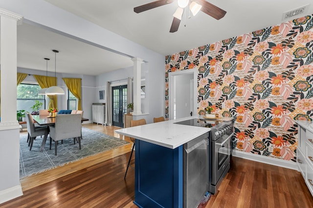 3100 29th Ave S, Minneapolis, MN 55406 - kitchen with decorative columns, baseboards, dark wood-style flooring, light countertops, and wallpapered walls
