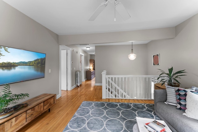 3100 29th Ave S, Minneapolis, MN 55406 - living room featuring light wood-style floors, radiator heating unit, ceiling fan, and baseboards
