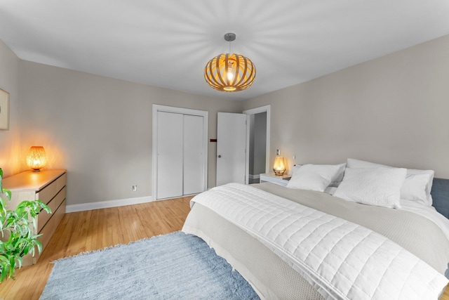 3100 29th Ave S, Minneapolis, MN 55406 - bedroom with light wood-style flooring, baseboards, a chandelier, and a closet