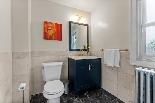 3100 29th Ave S, Minneapolis, MN 55406 - bathroom with radiator heating unit, tile walls, marble look tile flooring, toilet, and vanity