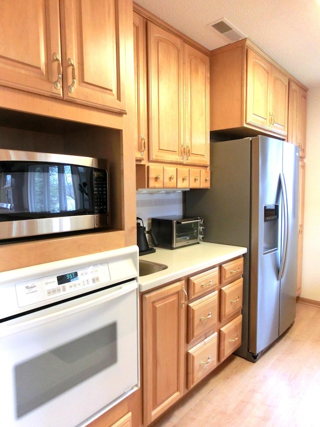 499 Tamarack Ct NE, Tenstrike, MN 56683 - kitchen featuring stainless steel appliances, light countertops, light wood-style floors, and light brown cabinetry