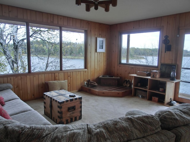 499 Tamarack Ct NE, Tenstrike, MN 56683 - carpeted living room with wood walls, ceiling fan, and a water view