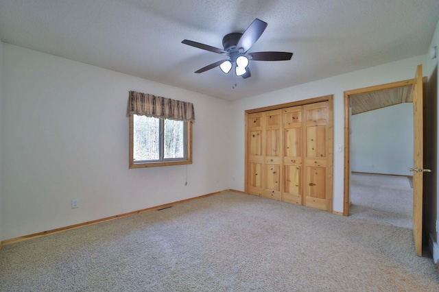 unfurnished bedroom with carpet flooring, baseboards, a ceiling fan, and a closet