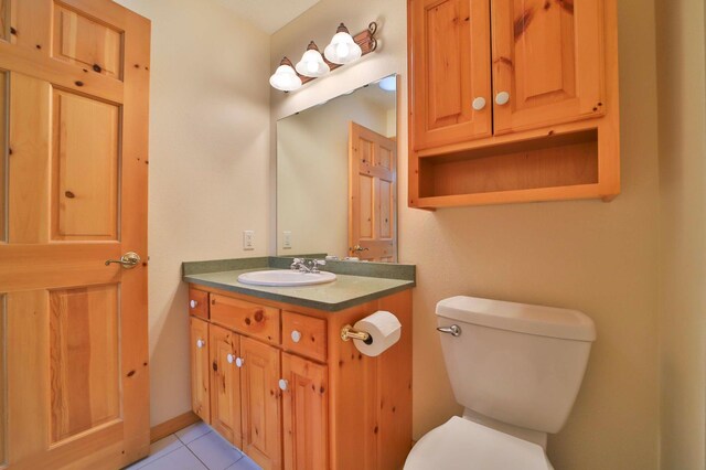 bathroom with toilet, vanity, and tile patterned floors