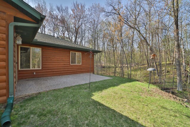 view of green lawn with a patio